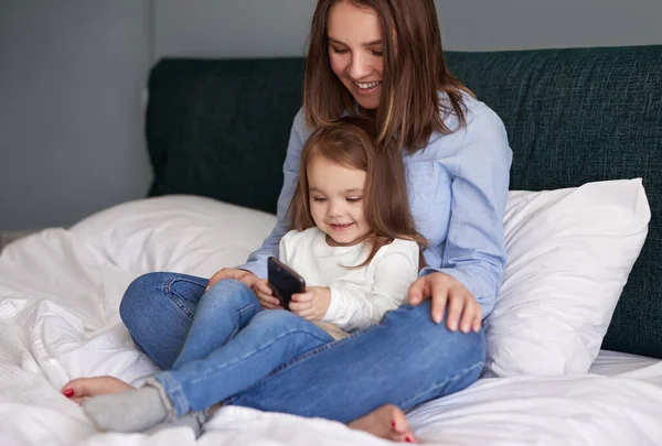 Mutter und Tochter nutzen gemeinsam Smartphone — Stockfoto