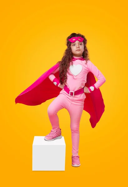 Criança super-herói grave em traje rosa e máscara em estúdio — Fotografia de Stock