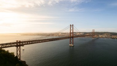 Gün batımında nehir üzerinde asma köprü