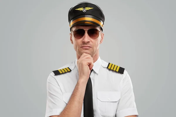 Confident airline pilot in uniform thinking