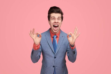 Heyecanlı komedyen iş adamı Tamam jest gösteriyor