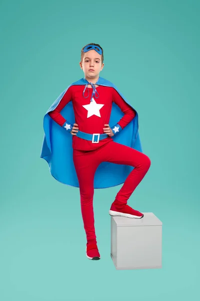 Впевнений супергерой хлопчик в костюмі в студії — стокове фото