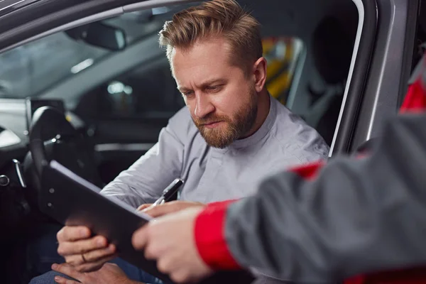 Auto monteur en klant met rapport op klembord — Stockfoto