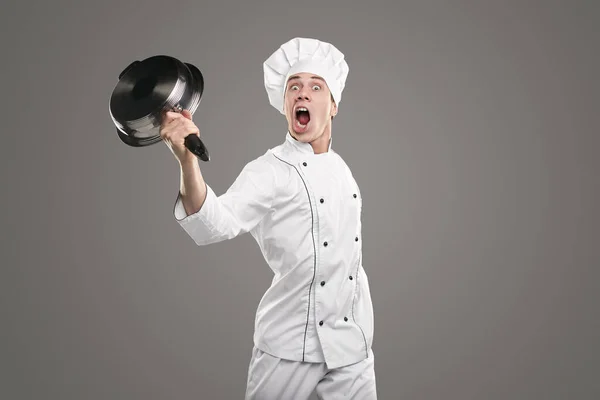 Szalony kucharz krzyczy głośno z podniesioną patelnią — Zdjęcie stockowe