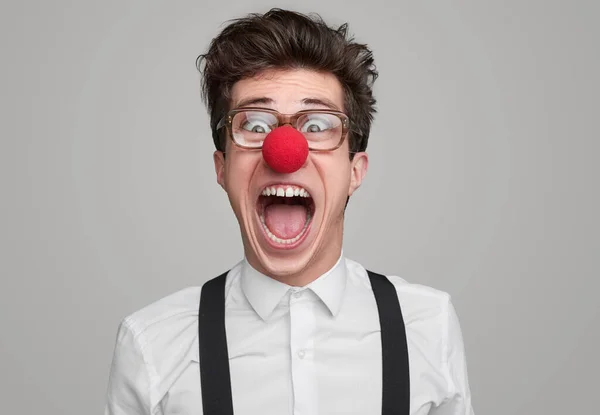 Crazy geek with clown nose screaming at camera — ストック写真