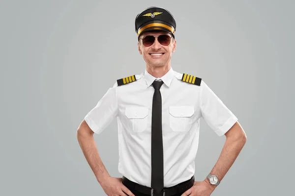 Lachende piloot in uniform kijkend naar camera — Stockfoto