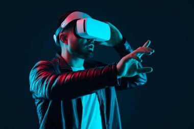 Sanal dünyayı keşfeden VR kulaklıklı hayret bir adam.