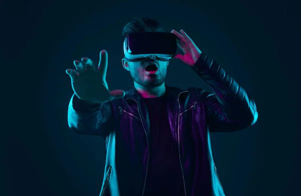 Geschokte man in VR bril in studio met neon verlichting — Stockfoto