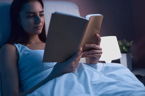 Donna che legge libro a letto prima di dormire — Foto Stock