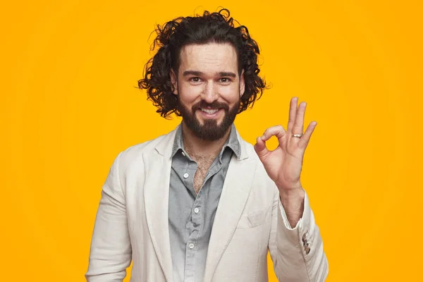 Smiling man showing OK sign in studio — Fotografia de Stock