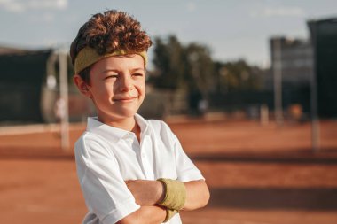 Tenis kortunda gülümseyen çocuk