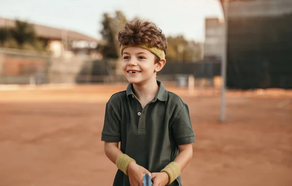 Щасливий хлопчик тренується на тенісному корті — стокове фото