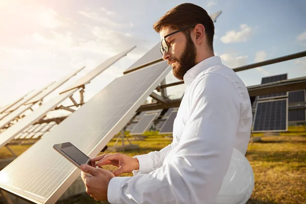 İş adamı güneş enerjisi istasyonunda tablet kullanıyor — Stok fotoğraf