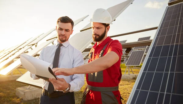 Contractor and manager working in field with solar panels — Stockfoto
