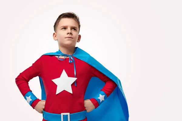 Brave superhero kid looking up in studio — Stock fotografie