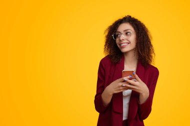 Stylish female using smartphone and smiling