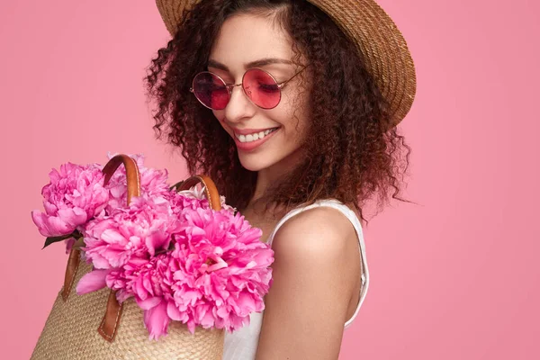 Ευτυχισμένη γυναίκα με ροζ λουλούδια στην τσάντα. — Φωτογραφία Αρχείου