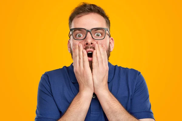 Shocked man touching face in studio — Fotografia de Stock