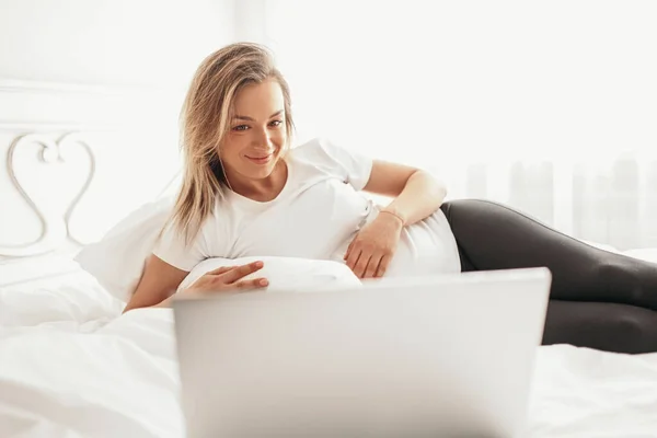 컴퓨터로 영화를 보고 있는 임산부 — 스톡 사진
