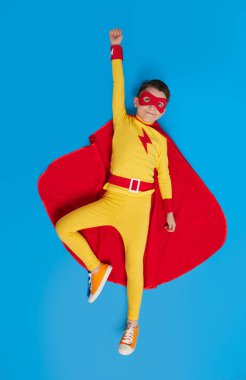 Superhero kid flying in studio