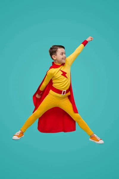 Aspired superhero boy with fist up in studio — Φωτογραφία Αρχείου
