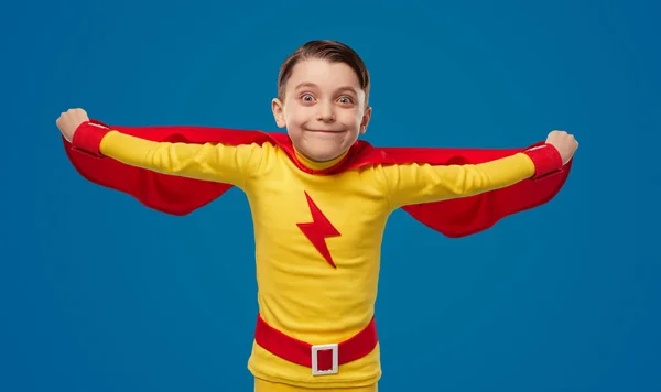 Funny boy in superhero cape in studio — Stockfoto