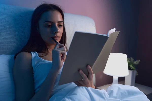 Woman writing in diary in bed — Foto Stock