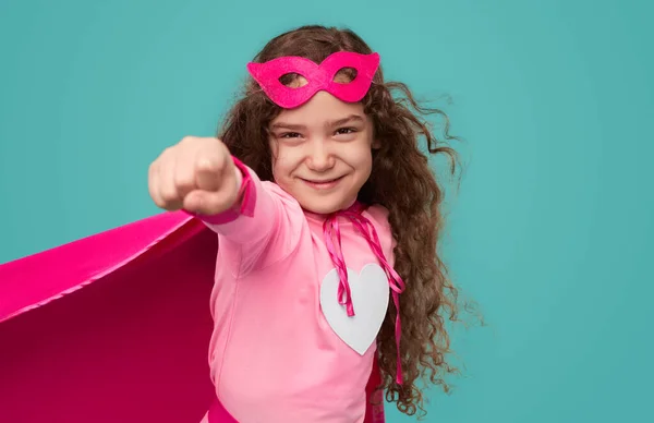 Strong girl in superhero costume and with clenched fist — Stockfoto