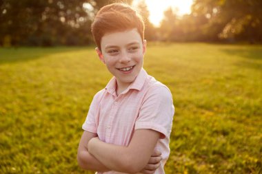 Content redhead boy in summer park
