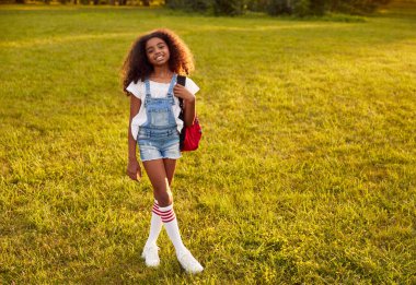 Parkta sırt çantalı siyah kız.