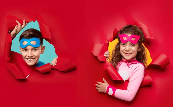 Щасливі діти супергероїв, які переглядають розірваний папір — стокове фото
