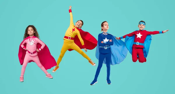 Compañía de niños superhéroes sobre fondo azul — Foto de Stock