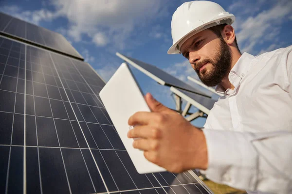 Grave ingegnere maschio che lavora sul campo con pannelli solari — Foto Stock