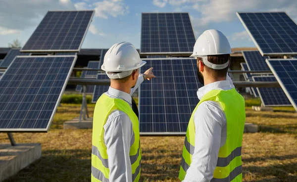 Técnicos trabalhando em campo com painéis fotovoltaicos — Fotografia de Stock