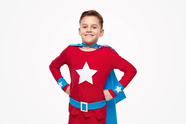 Glimlachend kind in superheld kostuum in studio — Stockfoto