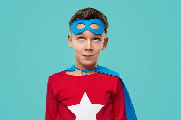 Vtipný superhrdina chlapec vzhlíží a dělá obličej — Stock fotografie