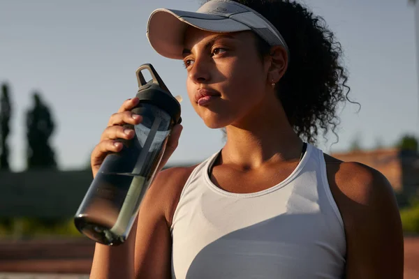Genç siyah sporcu kadın su içiyor. — Stok fotoğraf