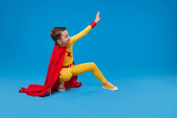 Superhéroe niño saludando mano en el estudio — Foto de Stock