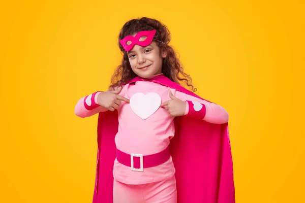 Chica sonriente en traje de superhéroe con corazón — Foto de Stock