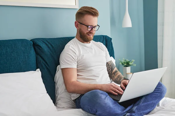 Samozatrudniony mężczyzna przeglądanie laptopa w domu — Zdjęcie stockowe