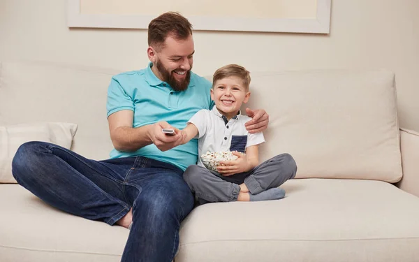 Alegre pai e filho assistindo TV em casa — Fotografia de Stock