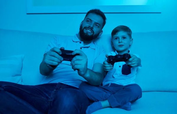 Zachwycony ojciec i syn grający w gry wideo w domu — Zdjęcie stockowe