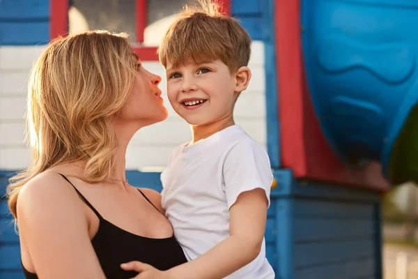 Matka całuje syna na placu zabaw — Zdjęcie stockowe