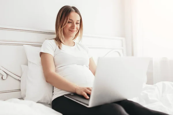 Pregnant woman working on laptop at home — Stock Photo, Image