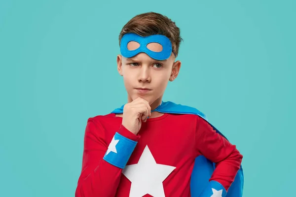 Thoughtful superhero boy in costume in studio — Stock Photo, Image