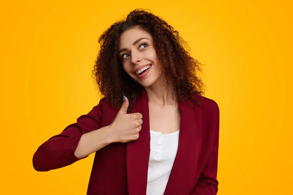 Smiling woman with curly hair showing thumb up — Stock Photo, Image