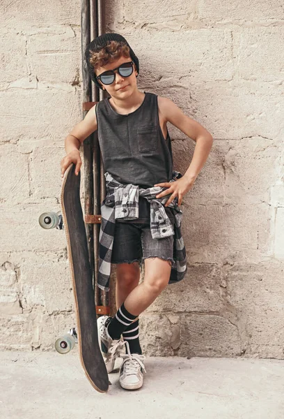 Крутий хлопчик зі скейтбордом у місті — стокове фото