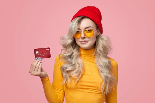 Trendy woman showing plastic card in studio — Stock Photo, Image