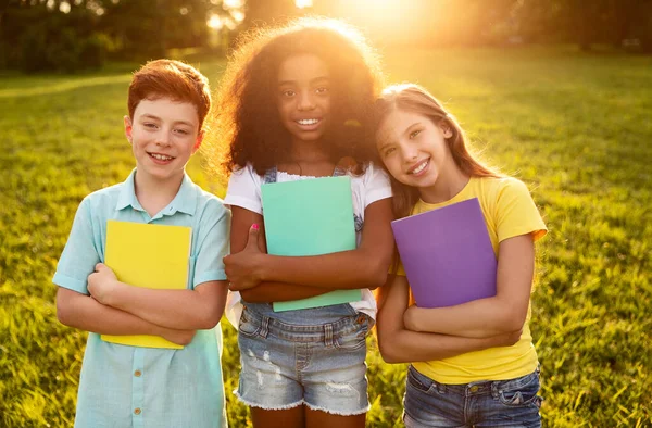 Diverse leerlingen met leerboeken in het park — Stockfoto