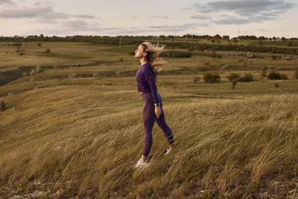 Sportswoman godendo il vento nella natura — Foto Stock